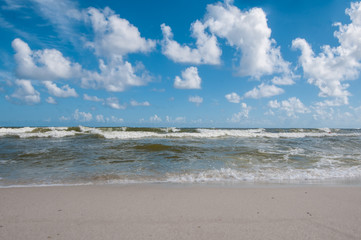 Fototapeta na wymiar Blue sky and waves on beach at Gulf Shores Alabama