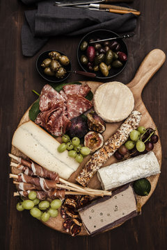 Charcuterie and cheeses on wooden board