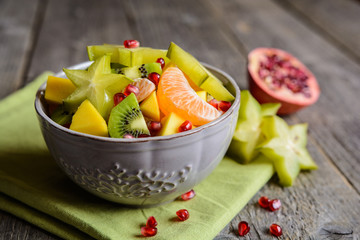 Juicy fruit salad with kiwi, mango, mandarin, carambola and pomegranate