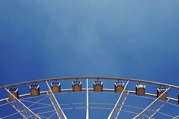 Part of Ferris wheel against blue sky
