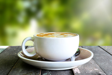 Coffee cup on wooden table and blur background.