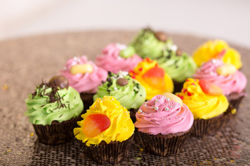 Cupcakes. yellow, green and pink cakes.
