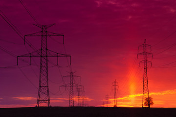 Transmission towers on the field at sunset