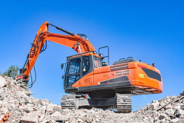 Recycling - Bagger bei Abrissarbeiten auf einem Schutthaufen