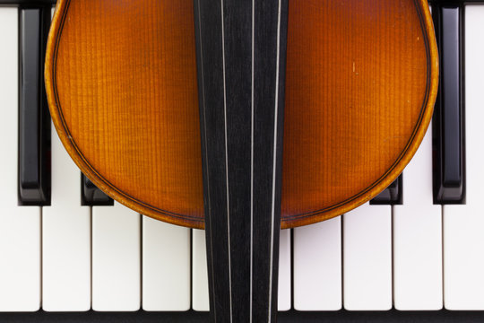 Old violin lying on the piano