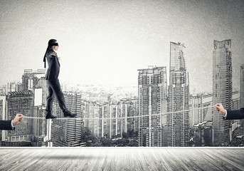 Fototapeta premium Business concept of risk support and assistance with man balancing on rope