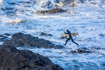 Surfers take advantage of the unusal mild weather with the continued big waves off the west coast.