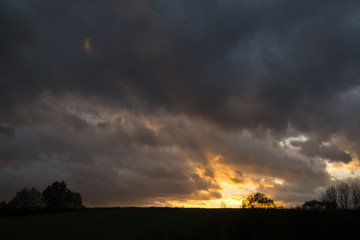 Fototapeta na wymiar Clouds and sunrays over the meadow. Slovakia