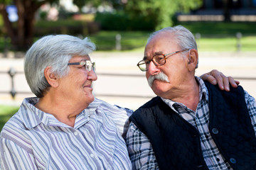 Senior couple embrace on bench