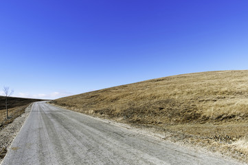 Fototapeta na wymiar Mountain road with pastures around