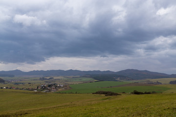 Fototapeta na wymiar Clouds and sunrays over the meadow. Slovakia