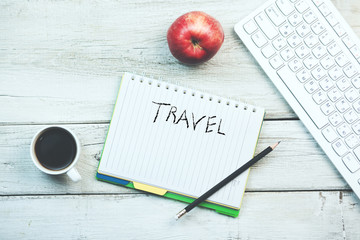 Word travel on notepad and keboard with coffee