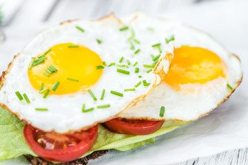Wooden table with Fried Eggs (on a Sandwich)