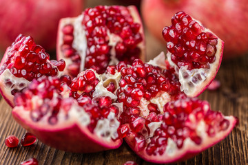 Pomegranate seeds on wooden background (selective focus)