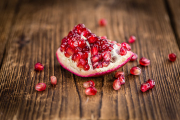 Pomegranate seeds on wooden background (selective focus)