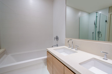 Modern bathroom interior with bathtub and two sinks. 