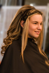 Fototapeta premium Girl with long curls in a hairdressing salon