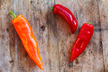 Orange und rote Paprika auf Holzuntergrund