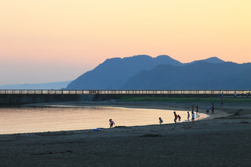 夕日の浜辺で遊ぶ子供たち