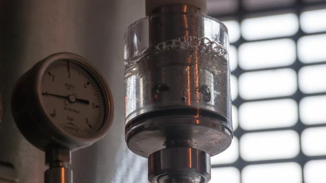 Microbrewery equipment HD slow-motion video. Gauges pressure control device: manometer at craft brewery. Water gurgles and water bubbles.