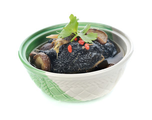 Black chicken stewed with Chinese herbs on white background.