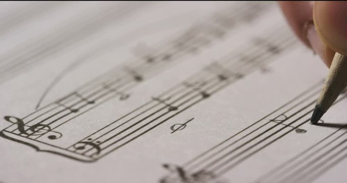 A musician or composer composes a song or a musical work, writing notes in pencil on the pentagram. The composer, first hears the sound of the note then writes and so on is composed the music. Concept
