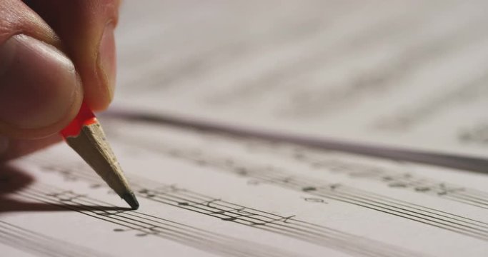 A musician or composer composes a song or a musical work, writing notes in pencil on the pentagram. The composer, first hears the sound of the note then writes and so on is composed the music. Concept
