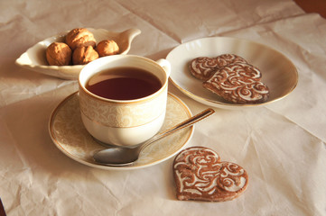 White cup of tea with cookies in form of heart 