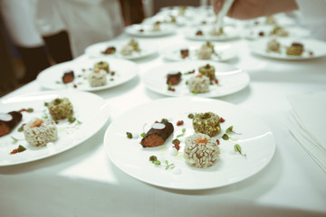 chef using chopsticks tong sliced beef put on the white plate in