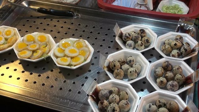 Asian food. Quail Eggs. A display of both cooked and fresh Quail eggs in an Asian market.
