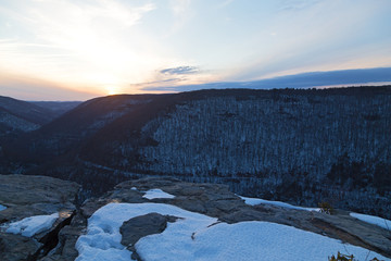 Quiet sunset at Blackwater Falls Park in winter, West Virginia, USA. Horizon over Appalachian Mountains and a road trace in canyon.