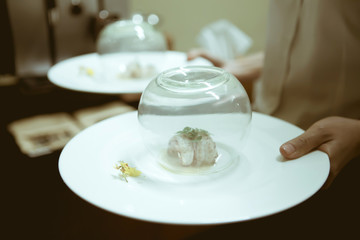 Waiter serving food in luxury dinner party, Blurry background wi