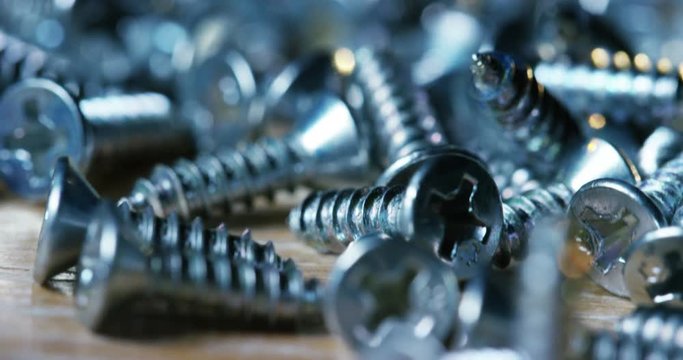 bolts and screws on a wooden work bench. concept of DIY and new screws or bolts. working tools in carpentry and home DIY. and self-tapping steel screws