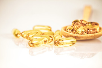 Closeup yellow soft gelatin supplement fish oil capsule