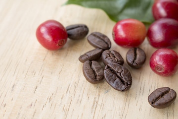 coffee berry and coffee beans on wooden panel