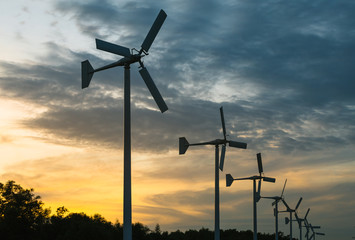 Wind generators turbines on sunset summer landscape 