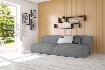 Obraz premium White room with sofa and green landscape in window. Scandinavian interior design