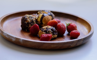 freshly picked ripe strawberries and homemade cookies served on a wooden plate