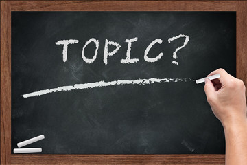 Topic word chalkboard with hand hold chalk on wooden board dirty with chalk stain empty space for...