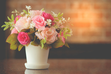 Flowers decoration in a vase On the table on abstract blurry brick wall, valentine day