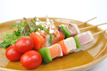 3 barbecue sticks grilled lay on brown plate