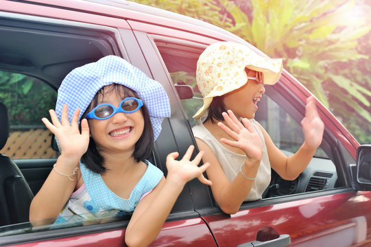 Smiling Happy Asian Children Waving Hands On The Car