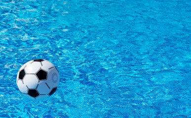 Fototapeta na wymiar Beach ball floating in blue swimming pool. Space for text.