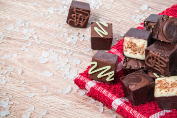 Delicious chocolate candies on the wooden background.