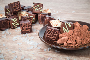 Delicious chocolate candies on the wooden background.