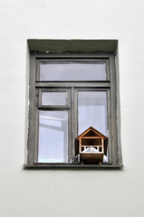 Old wooden window with a wood birdhouse.