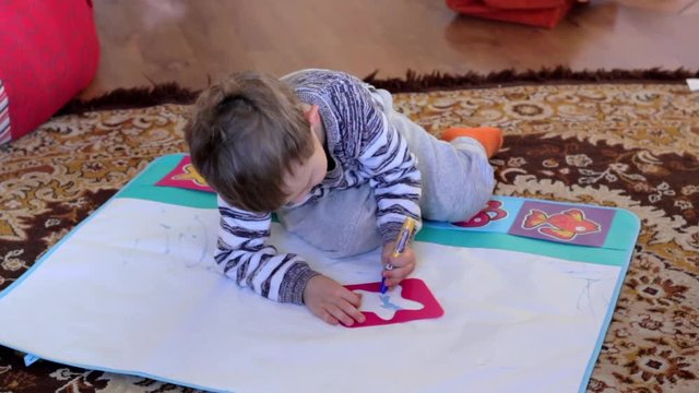 child drawing on  water mat, aquadoodle