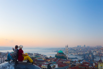 Obraz premium Sunrise View of Istanbul City and Couple sitting on Roof