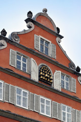 A fragment of the old facade of the building. A window is decorated with lots of bells. Lindau, Bavaria, Germany.