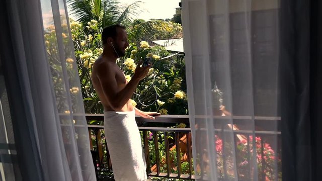 Man in towel listening to music, dancing, singing on terrace, super slow motion 240fps
